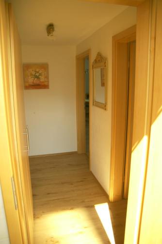 an empty room with a hallway with a wooden floor at Gästehaus Gaisalpe in Fischen