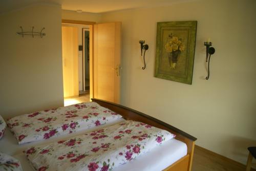 a bedroom with a bed and a picture on the wall at Gästehaus Gaisalpe in Fischen
