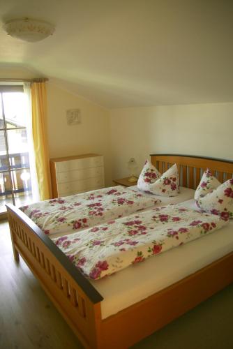 a bedroom with a large bed with flowers on it at Gästehaus Gaisalpe in Fischen