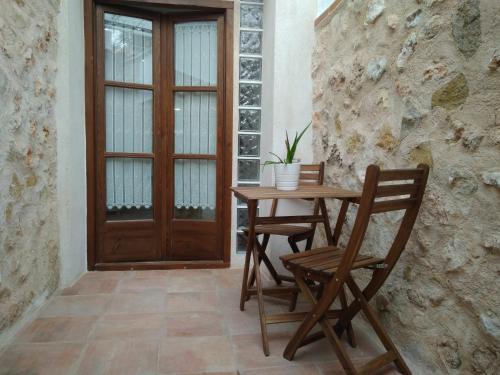 una mesa de madera, 2 sillas y una puerta en Casa la Isabelica, en Belmonte