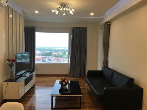 a living room with a black couch and a television at Nancy Vung Tau in Vung Tau