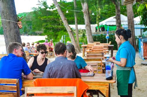 a group of people sitting at a table at Baan Tubkaek Hotel in Tab Kaek Beach
