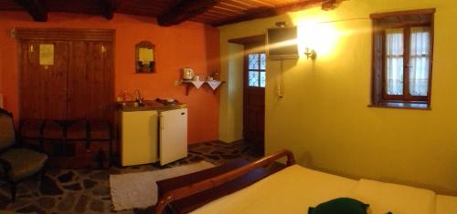 a kitchen with a refrigerator and a table in a room at Traditional Rooms karaouli in Papigko