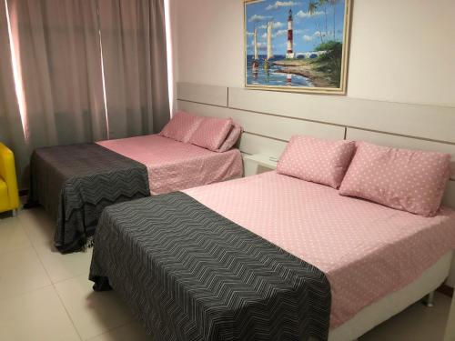 Habitación con 2 camas y una pintura en la pared. en Luxury 3 Bedroom Apartment - Barra, en Salvador