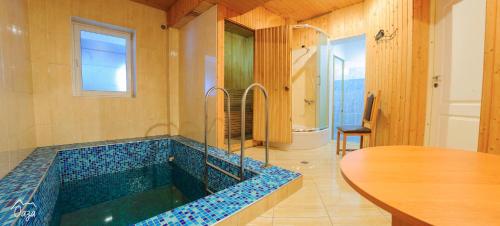 a bathroom with a jacuzzi tub with a table at Оаза in Dragobrat