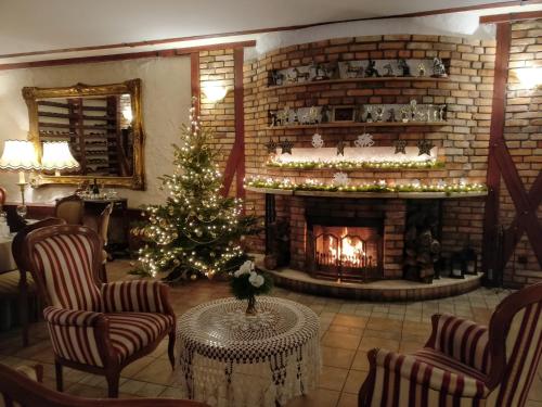 a living room with a christmas tree and a fireplace at Hubertus Aparthotel & Restaurant & Horse Club in Starogard Gdański