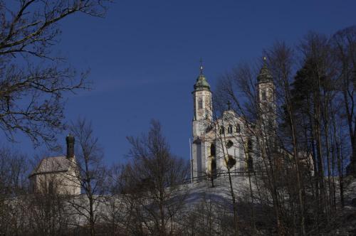 an old building with two towers on a hill at Malerhaus am Kolbergarten in Bad Tölz