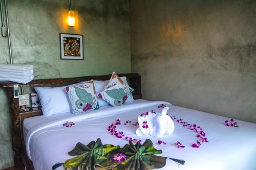a bedroom with a bed with flowers on it at Baan Tubkaek Hotel in Tab Kaek Beach