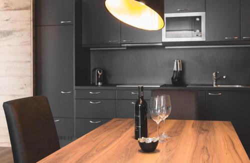 a wooden table with a bottle of wine and two glasses at Residenz Gramaser GmbH in Ischgl