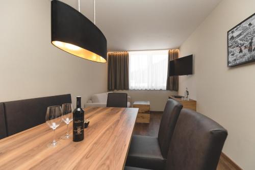 a dining room with a wooden table with wine glasses at Residenz Gramaser GmbH in Ischgl