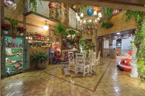 ein Restaurant mit einem Tisch, Stühlen und Pflanzen in der Unterkunft Hotel Palazzo Reale in Campos do Jordão