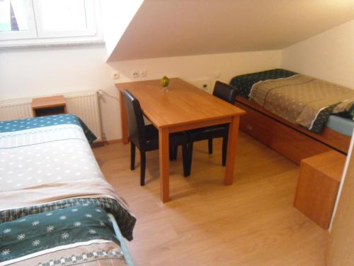 a small room with a table and two beds at Gostilna Ulčar in Ig