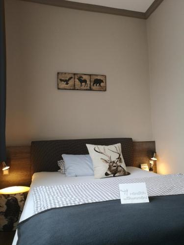 a bedroom with a bed with a sign on it at Hotel am Kurpark in Bad Lauterberg