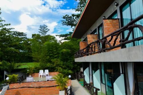 a building with white chairs and a balcony at Baan Tubkaek Hotel in Tab Kaek Beach