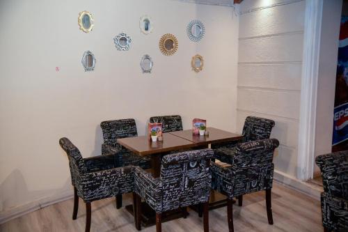 Loutrópolis Thermís的住宿－Palataki Studios，餐桌和椅子,墙上挂有盘子