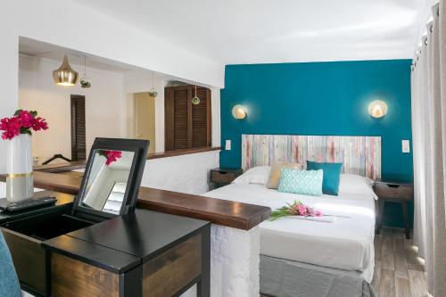 a room with a desk and a bed with a mirror at Koho SXM - ex Hevea Hotel in Grand Case