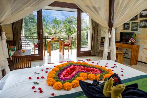 a large flower arrangement in the middle of a bed at Ayu Duwur Beji in Ubud