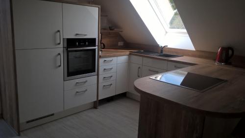 a kitchen with white cabinets and a counter top at A&C Bergen in Luckau