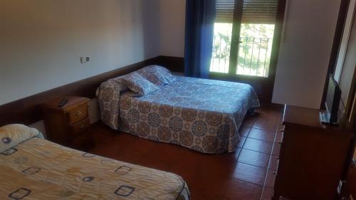 um quarto de hotel com duas camas e uma janela em HOSPEDAJE CASA MARIANO em Segóvia