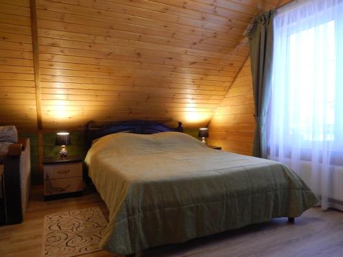 スーズダリにあるДом для отдыха с саунойの木製の壁のベッドルーム1室(ベッド1台付)