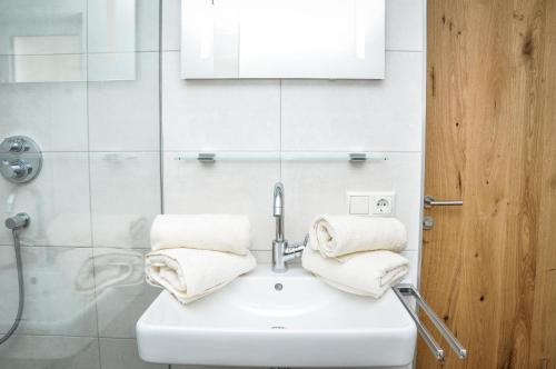 ein Bad mit einem Waschbecken und Handtüchern darauf in der Unterkunft Bergruh Steeg in Steeg