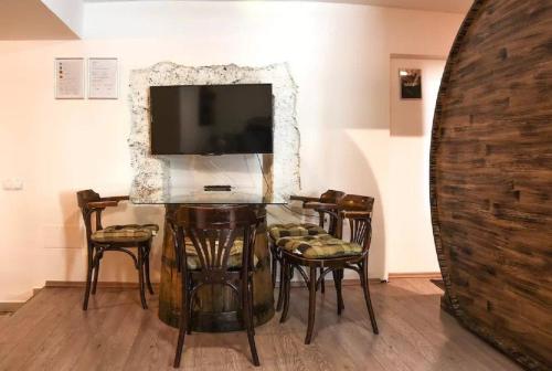 a dining room with a table and chairs and a tv at Apartments FABRKA in Ljubljana