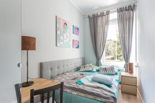 a bedroom with a bed and a desk and a window at Babel Hostel, Dworzec PKP, Rynek in Wrocław