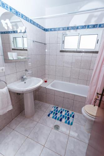 a bathroom with a sink and a tub and a toilet at Calheta Holiday Houses in Arco da Calheta