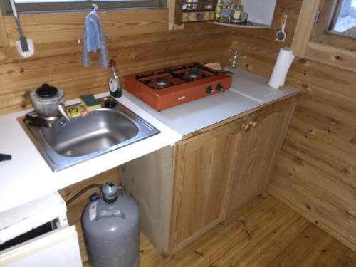 a small kitchen with a sink and a stove at Kalliomökki in Puumala