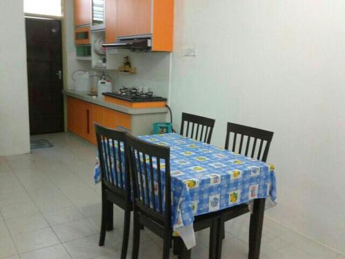 a kitchen with a table and two chairs with a table and a table at GERIK BANDING HOMESTAY in Gerik