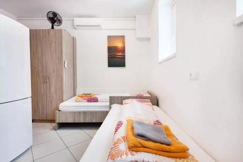 a small room with two beds and a refrigerator at Apartments FABRKA in Ljubljana