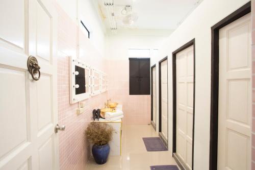 a hallway with pink walls and a white door at The Orientale Hostel in Bangkok