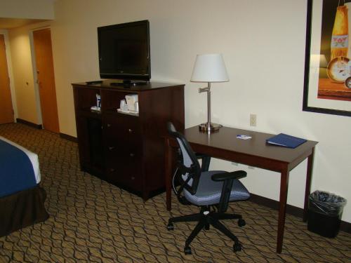 a hotel room with a desk with a television and a chair at Holiday Inn Express Scottsdale North by IHG in Scottsdale