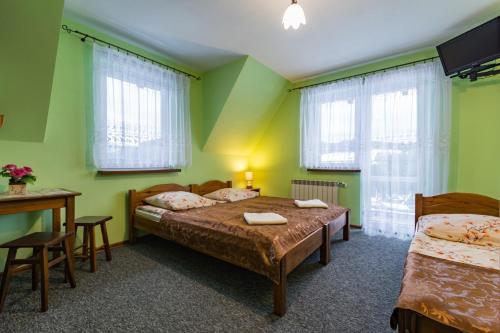 マウェ・チヘにあるPokoje Gościnne Stanekのベッドルーム1室(ベッド2台、テーブル、椅子付)