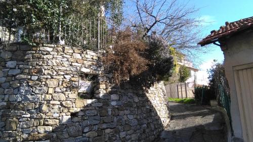 uma parede de pedra em frente a uma casa em Alloggio Basilico em Diano San Pietro
