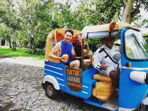 a group of three men sitting in a small food truck at Old Parkland Hostel in Galle