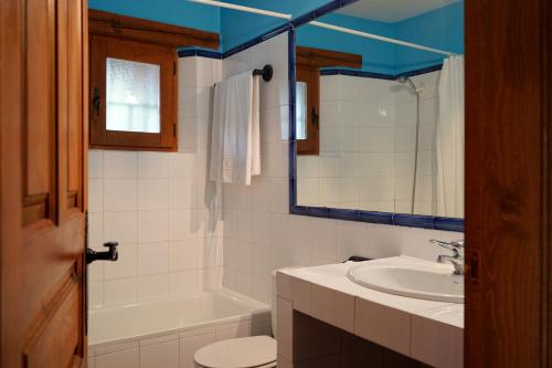 uma casa de banho com um lavatório, um WC e um espelho. em La Tejera de Fausto em Requijada