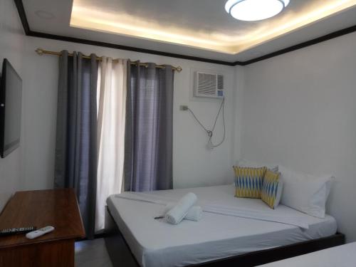 a small bedroom with a bed and a window at Aquilah Homestay Inn in Coron