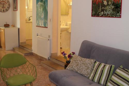 a living room with a couch and a chair at Adria Apartments in Podgora