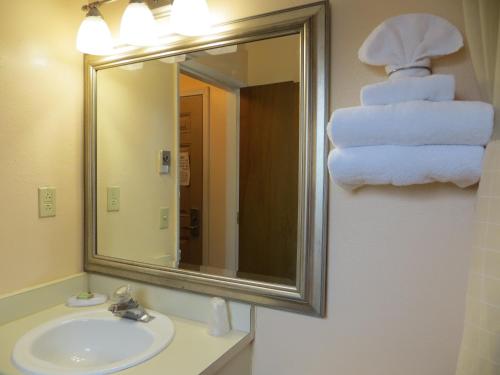 a bathroom with a sink and a mirror and towels at Cameo Motel - Portland in Portland