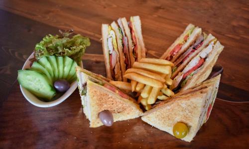 a sandwich and french fries and a bowl of fruit at Romance Alexandria Hotel in Alexandria