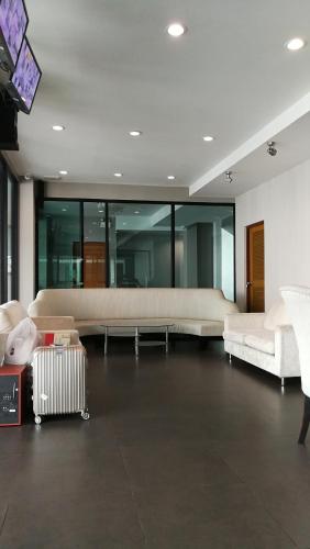 a living room with white couches and a tv at Abani Inn in Jomtien Beach