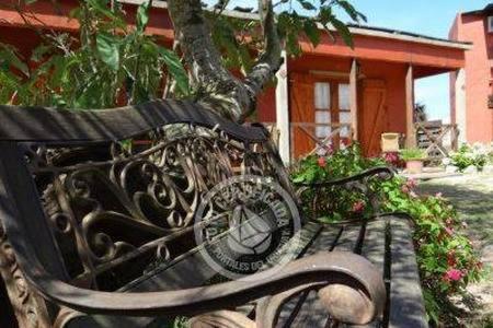 un banco negro sentado frente a una casa en Complejo Los Girasoles, en Punta del Diablo