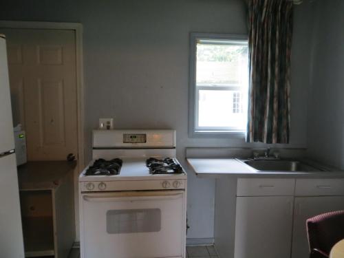 a kitchen with a stove and a sink and a window at Madison Suites Motel in Portland