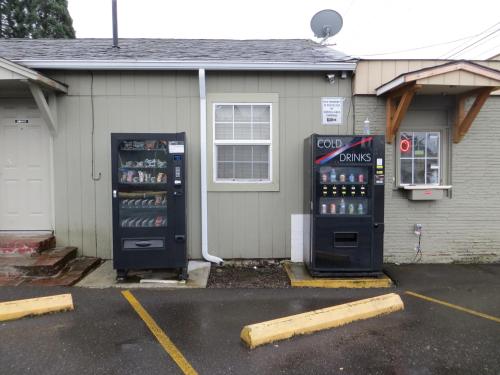 two soda machines are parked outside of a house at Madison Suites Motel in Portland