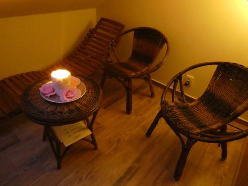 a room with three chairs and a candle on a table at Ubytování Farma U sv. Jakuba in Dolní Lánov