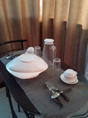 a table with a white plate and fork and knife at De Hagan Transient Baguio City in Baguio