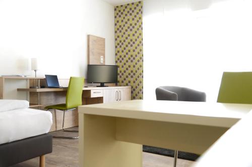una oficina con sillas, mesa y escritorio en Adapt Apartments Giessen, en Giessen