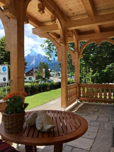 a wooden pergola with a bench on a patio at Der Ulmenhof in Gosau
