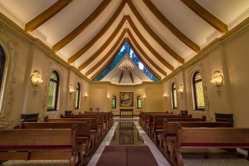 a church with wooden pews and a large ceiling at Hotel Ritta Höppner in Gramado